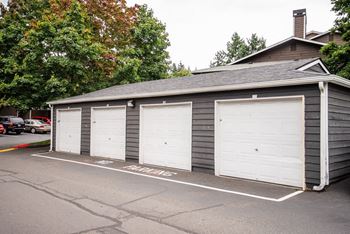 a garage with white doors on the side of a house